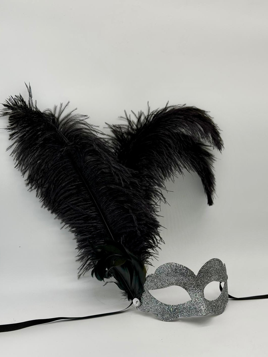 Venezianische Maske aus silbernem Glitzer mit schwarzen Federn